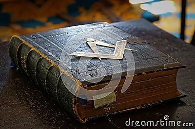 Ancient Masonic Holy Bible book with darkened pages and old bookmarks in dark brown leather cover with Square and Stock Photo