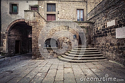 Ancient medieval house. In brick and stone, exterior part with entrance and stairs. Stock Photo