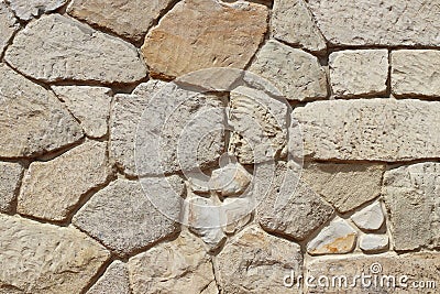 Ancient medieval stone masonry. Texture of a fragment of a wall of an old structure. A background for design and creative work. De Stock Photo