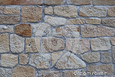 Ancient medieval stone masonry. Texture of a fragment of a wall of an old structure. A background for design and creative work. De Stock Photo