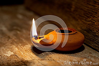 Ancient Middle Eastern oil lamp made in clay on wood table Stock Photo