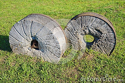 Ancient millstone on the grass, natural background Stock Photo