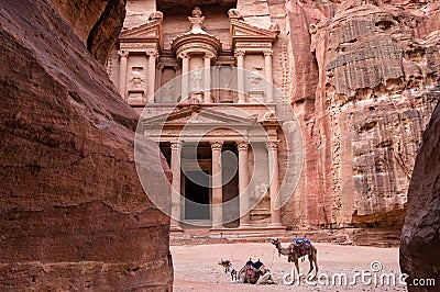 Ancient nabataean temple Al Khazneh Treasury located at Rose city - Petra, Jordan. Two camels infront of entrance. View from Siq Stock Photo