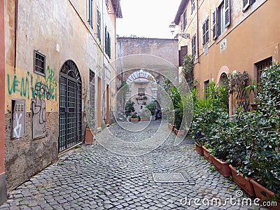 Ancient narrow street with votive niche deep down in the Trastevere distrct to Rome in Italie. Editorial Stock Photo