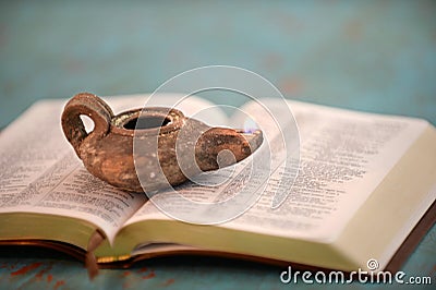 Ancient Oil Lamp on Open Bible Stock Photo