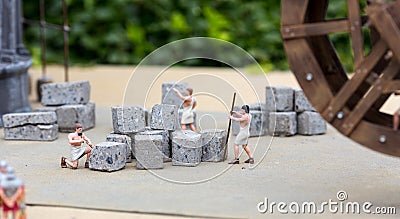 Ancient people works with stone, miniature scene Stock Photo