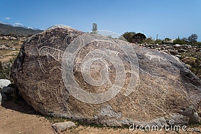 Ancient petroglyph - Hunting with tame snow leopards on the stone Stock Photo