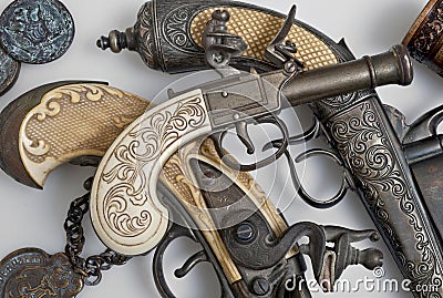 Ancient pistols and old coins. Stock Photo