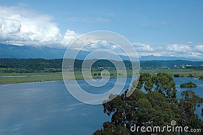 An ancient relict lake in Pitsunda. Mountains covered with snow in the background. Huge white clouds hang over the Stock Photo