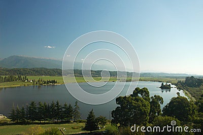 An ancient relict lake in Pitsunda, surrounded by cypresses and eucalyptus trees. Beyond the lake are mountains Stock Photo