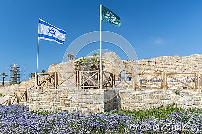 Ancient remnants of Ceasarea and waving flag of Israel in Maritima National Park in Caesarea, Israel Editorial Stock Photo