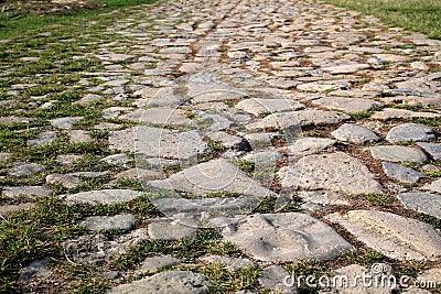 Ancient road paved with cobblestone. Closeup. Stock Photo