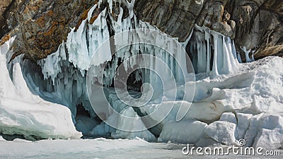 Ancient rocks at the entrance to the grotto are covered with bizarre icicles and frozen splashes. Stock Photo