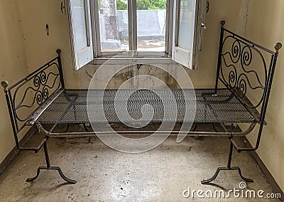 Ancient rusty iron bed in an abandoned and ruined room Stock Photo