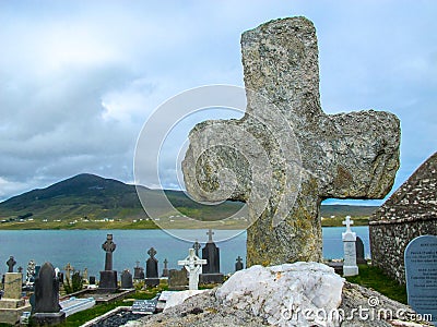 Ancient Stone Cross overlooking a very rural graveyard Stock Photo