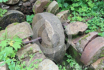 Ancient stone wheel of abandoned water mill to grind flour Stock Photo