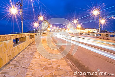 Ancient town of Nesebar UNESCO - protected. Road, night lights, windmill. Car light trails. Long exposure photo taken Stock Photo