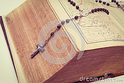 An ancient, very thick bible and a holy rosary. Catholicism. Prayer time Stock Photo