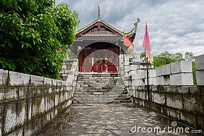 Ancient wooden gatehouse of stone fort in cloudy spring after ra Stock Photo