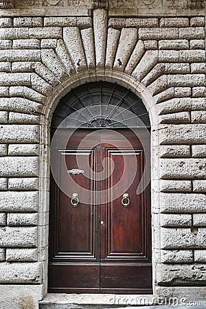 Ancient wooden portal with carved stone arch of an Italian medieval fortress Stock Photo