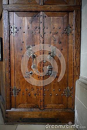 Ancient wooden sacristy door with skull and snake on door mounting, Saint Michael Church Schwabisch Hall, Germany Stock Photo