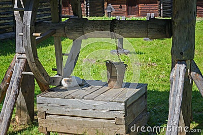 Ancient wooden water well and the cat Stock Photo