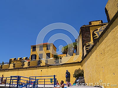 The ancient yellow Fortress of Sao Tiago with its bathing platforms into the Atlantic Ocean Editorial Stock Photo