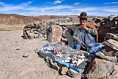 Andean lady sells items to tourists on a remote road in the Uyuni region of Bolivia Editorial Stock Photo