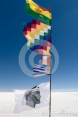 Andean peoples flag and South American countries flags, a landmark at the Uyuni Salt Flat, in Bolivia. Editorial Stock Photo