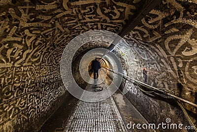 Anderlecht, Brussels, Belgium- Man walking in the industrial interiors of the sewer museum showing the main tunnel of the Chaussee Editorial Stock Photo