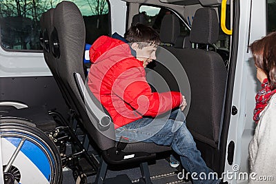 Andicapped boy is picked up by the school bus Stock Photo