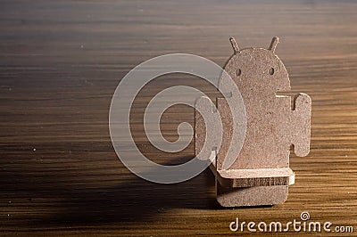 Android made of MDF wood, placed on a wooden table with copy space left,future concept, mobile operating system Editorial Stock Photo