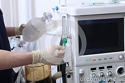 The anesthesiologist turns on the machine for artificial ventilation of the lungs. Surgery under anesthesia.Oxygen level sensor. Stock Photo