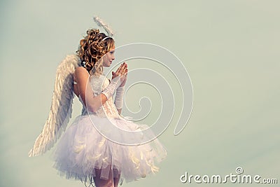 Angel child girl with curly blonde hair - Innocent girl concept. Teenager Cherub Cupid. Child with angelic character Stock Photo
