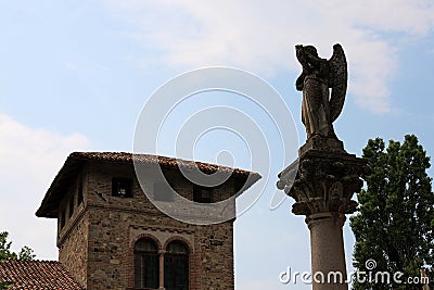 Angel on a column. Medieval house Stock Photo