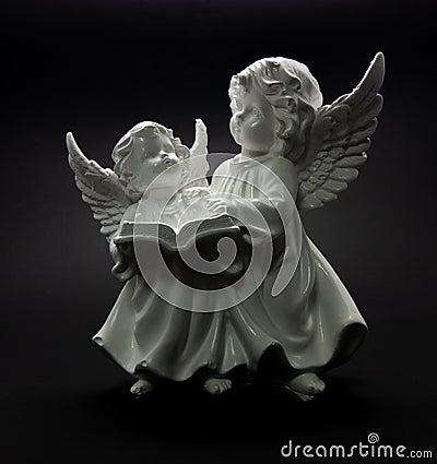 Guardian angel on a dark background two angels are reading a book Stock Photo