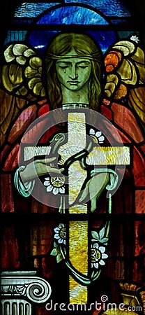 An angel holding a cross in stained glass Editorial Stock Photo