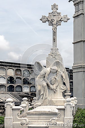 Angel sculpture and crucifix on grave in Poblenou Cemetery in Barcelona, Spain Editorial Stock Photo