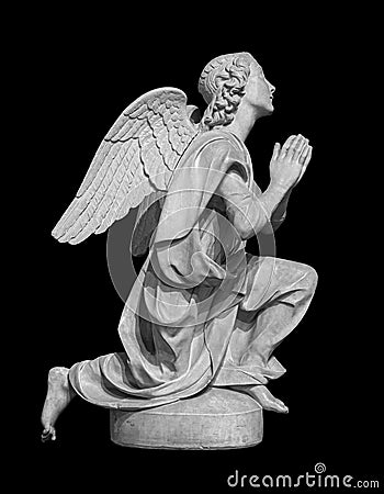 Angel statue isolated on black background. White stone sculpture of praying cherub Stock Photo