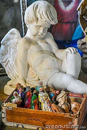 Angel Statue Looking At a Box of Nativity Statues Editorial Stock Photo