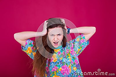 Anger and rage concept. Young expressive woman show her bad face. Angry nervous annoyed girl portrait on red background Stock Photo
