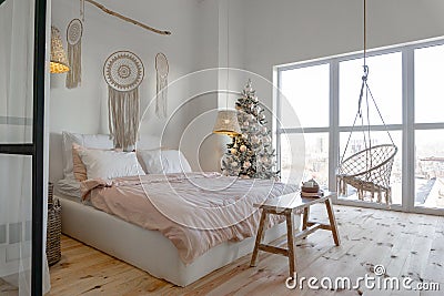 Angle view on spacious white bedroom with big windows decorated with Christmas New year tree and tea set Stock Photo