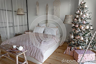 Angle view on spacious white bedroom decorated with Christmas New year tree and tea set Stock Photo