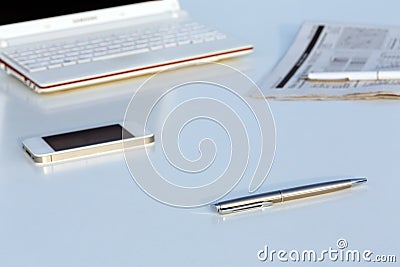 Angle View of Work Place with Laptop Pen and Newspaper Stock Photo