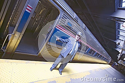 Angled view of conductor at Amtrak train platform announces All Aboard at East Coast train station on the way to New York City, Ne Editorial Stock Photo