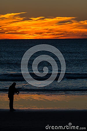 Angler with fishing rod on the beach Stock Photo