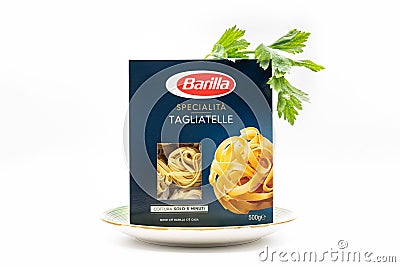 Angri, Italy. September 2th, 2020. Pack of Italian tagliatelle pasta noodles in cardboard package placed in a plate with a sprig Editorial Stock Photo