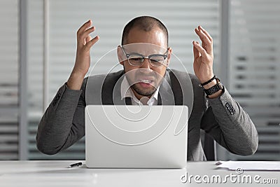 Angry african business man using laptop mad about computer problem Stock Photo