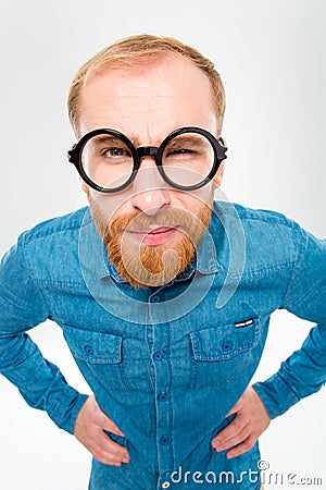 Angry amusing young man with beard in funny round glasses Stock Photo