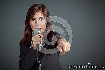 Angry Asian business girl hold a microphone and point Stock Photo